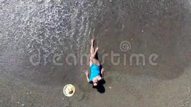 一个女人喜欢度假，躺在海滩上的水里。 暑假概念。